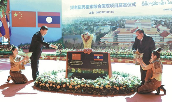 President Xi Jinping and Laotian President Bounnhang Vorachith place flowers during a ceremony on Tuesday marking the start of work on a hospital expansion in Vientiane, Laos, involving money and medical equipment from China. (MA ZHANCHENG / XINHUA)