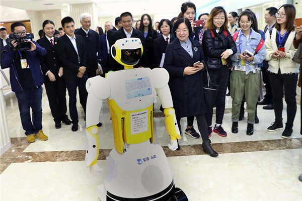 Xiao Fa, a robot assistant, is surrounded by officials during its first day at Beijing No 1 Intermediate People's Court last month. (Zou Hong/China Daily)