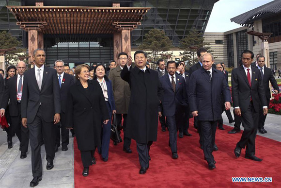 Xi Jinping and other leaders and representatives from the Asia-Pacific Economic Cooperation (APEC) walk to plant trees to mark friendship in the APEC family in Beijing, capital of China, Nov. 11, 2014. (Xinhua/Lan Hongguang)