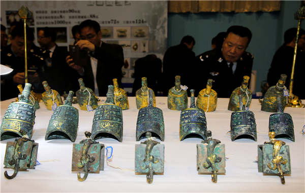 People examine relics on Tuesday that were recovered in a special operation in Xi'an, Shaanxi province. The launch of China's national internet platform that provides information about lost or stolen cultural relics will help netizens create even more successes.（Photo：China Daily/Huo Yan）
