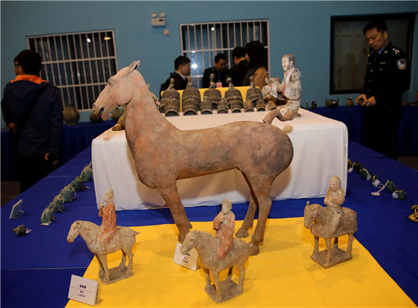 People examine relics on Tuesday that were recovered in a special operation in Xi'an, Shaanxi province. ��Photo��China Daily/Huo Yan��