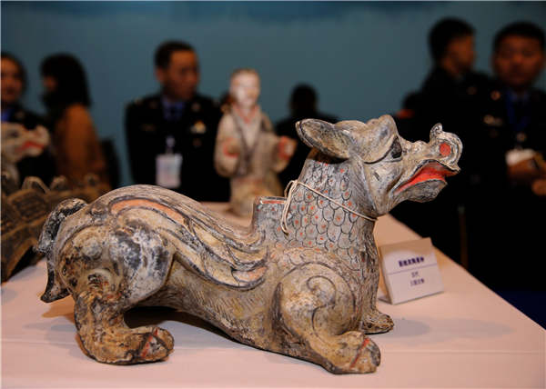 People examine relics on Tuesday that were recovered in a special operation in Xi'an, Shaanxi province.��Photo��China Daily/Huo Yan��