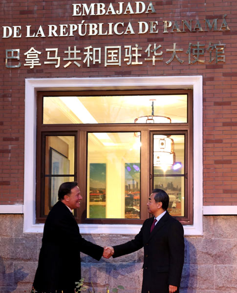 Foreign Minister Wang Yi and visiting Panamanian President Juan Carlos Varela shake hands at the inauguration ceremony of Panama's embassy in Beijing on Thursday. (Photo:China Daily/Zou Hong)