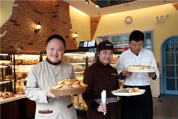 Liu Shunli, Yang Xiao and another store assistant poses with pastries at the bakery in Beijing. (Photo by Zou Hong/China Daily)