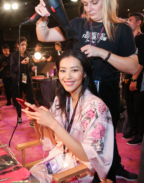 Chinese super model Liu Wen gets ready backstage before the 2017 Victoria's Secret Fashion Show in Shanghai on Monday. It is the first time that the show is held in Asia.(Photo/Xinhua)