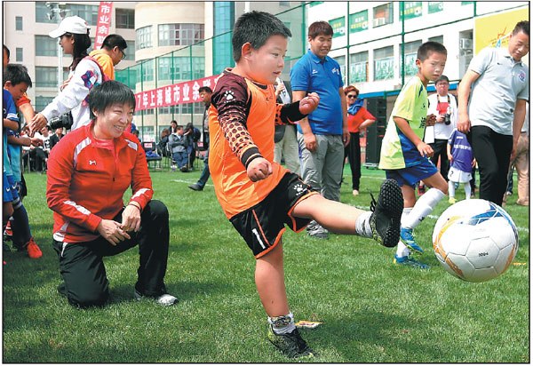 Sun Wen, who was named FIFA Female Player of the Century in 2000, watches kids get their kicks during the Shanghai Soccer Festival in May, The festival was run in conjunction with the city's junior soccer tournament, which was part of the inaugural year-long Shanghai Amateur Games. (Photo: Xinhua/Fan Jun)