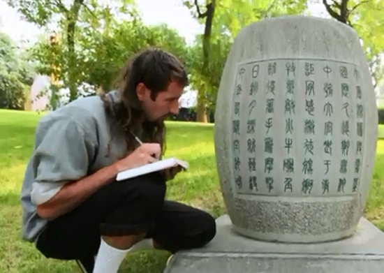 A still photo from a video shows Ben Giaimo learning ancient Chinese characters from a stone inscription, which is both his major and hobby. [Photo/chinadaily.com.cn]