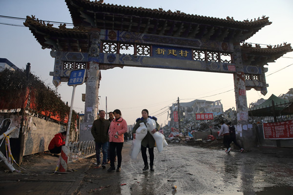 A business owner transports mannequins on Tuesday in Xinjian village of Beijing's Daxing district, as the village demolishes illegal buildings in the wake of a deadly fire that claimed 19 lives on Saturday. WANG JING/CHINA DAILY