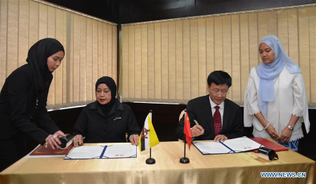 Cao Jianming (2nd R), Procurator-General of the Supreme People's Procuratorate of China, and Hajah Hayati (2nd L), the Attorney General of Brunei Darussalam, sign a joint statement on further enhancing cooperation between both sides in Bandar Seri Begawan, capital of Brunei, on Nov. 25, 2017. (Xinhua/Jeffrey Wong)