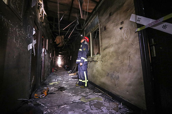 A firefighter checks the site on Sunday of the Nov 18 fire that killed 19 people and injured eight others in Xinjian village, Beijing's Daxing district. (Zou Hong/China Daily)