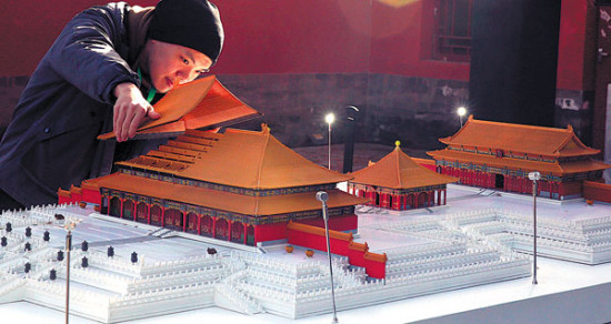 A 3D-printed model of a Forbidden City building is assembled by a Palace Museum staffer on Tuesday. JIANG DONG / CHINA DAILY