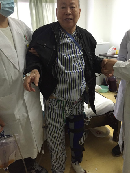 Zhang Jingui, 84, gets off the bed on the first day after the operation. (Photo provided to chinadaily.com.cn)