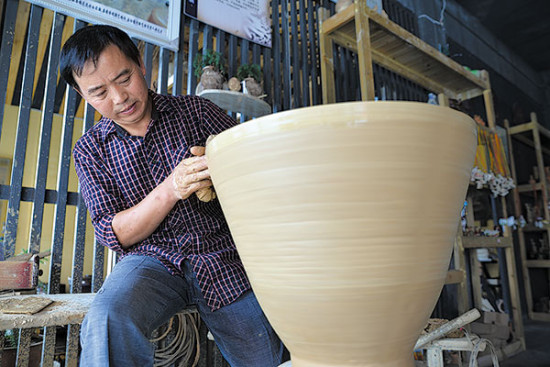 A potter in Huamao village in Zunyi, Guizhou province makes a ceramic container. Local potters increased their sales and income by promoting their products online. LUO XINGHAN/FOR CHINA DAILY