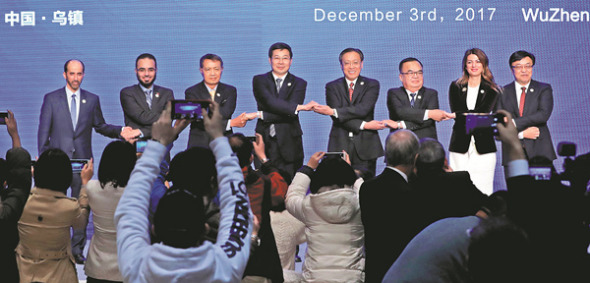 Chinese delegates Zhuang Rongwen and Lin Nianxiu and those from Laos, Thailand, Turkey, Serbia, United Arab Emirates and Saudi Arabia at a Belt and Road Initiative event pose at the fourth World Internet Conference in Wuzhen, Zhejiang province, on Sunday. Zhuang (fourth from left) is Cyberspace Administration deputy head. Lin (fourth from right) is National Development and Reform Commission vice-minister. (China Daily / Wu Zhiyi)