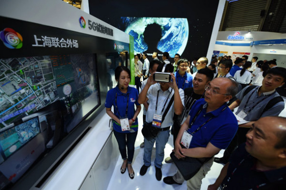 Visitors watch a live show of a 5G network trial test during the Mobile World Congress in Shanghai in June. (Photo provided to China Daily)