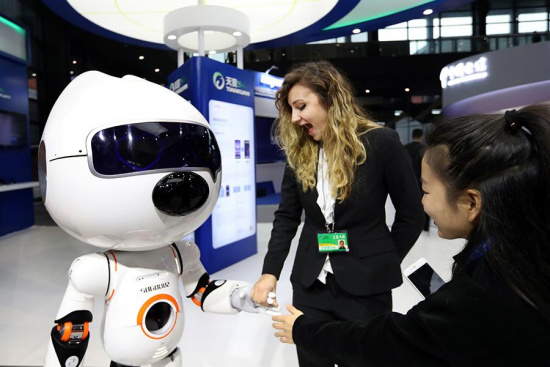 Bermal Kaplan (center) from Turkey interacts with a Sogou intelligent robot during the Light of the Internet Exposition, in Wuzhen, Zhejiang province, Dec 2, 2017. (Photo by Zou Hong / chinadaily.com.cn) 