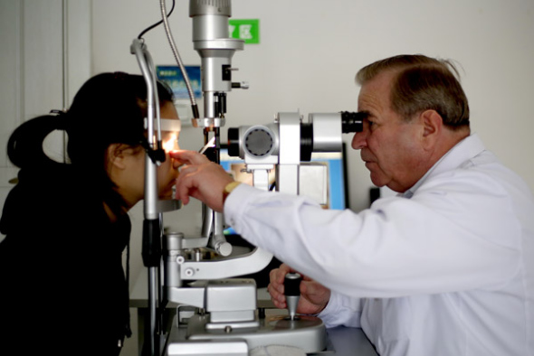 Russian ophthalmologist Nikola Vasilyevich Dusan examines a patient at Daqing Ophthalmic Hospital. (Photo by NANA/FOR CHINA DAILY)