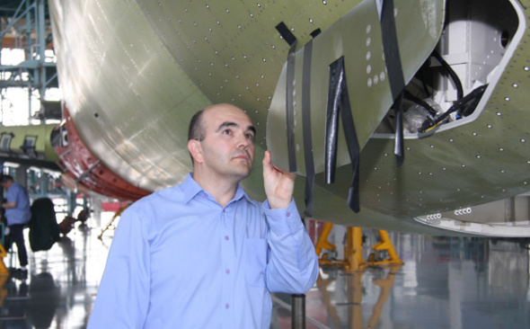Cyrille Breard, an engineer at the Commercial Aircraft Corporation of China who manages the noise and emission project of C919, China's domestically-made passenger plane, checks the components of a plane in production. (Wang Jiliang / For China Daily)