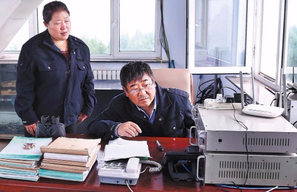Fire watchers Liu Jun and his wife Qi Shuyan in their watchtower in the forest. (Zou Hong/China Daily)