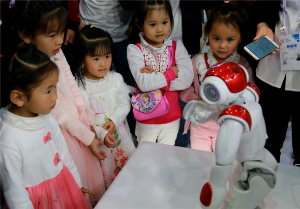 Children watch a robot in action at the expo.