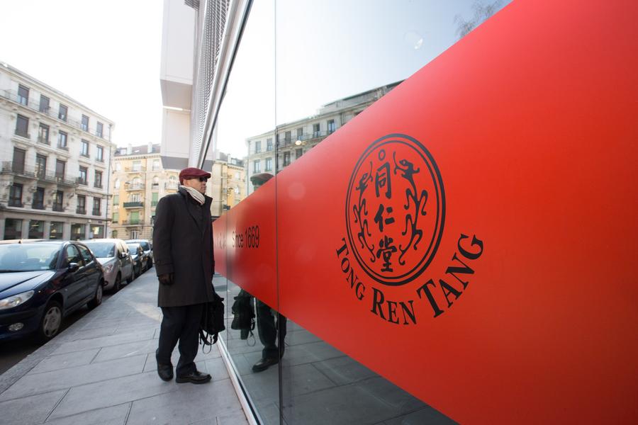 A passerby stops at the Tongrentang Chinese medicine store in Geneva, Dec 5, 2017. (Photo/Xinhua)