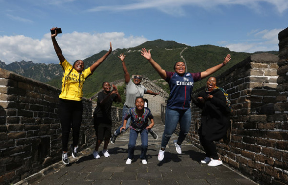 Foreigners celebrate at the Mutianyu section of the Great Wall in Huairou, Beijing, this summer. (Photo by BU XIANGDONG/FOR CHINA DAILY)