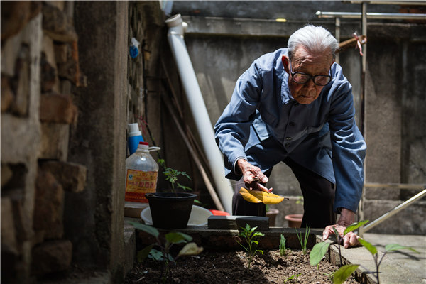 Guan Guangjing, the oldest Nanjing Massacre survivor until his death on Sunday, works in his vegetable garden. (Xinhua)