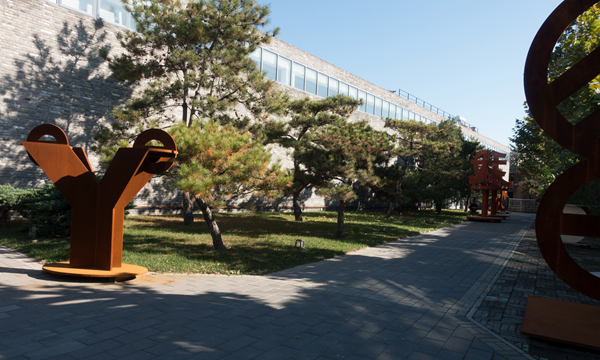 The main building of Huang Rui White Cloud House and artist Huang Rui's sculptures in the yard. The 1,200-square meter building is a cooperative product of Dutch designer Neville Mars and Chinese designer Bian Jing. (Photo provided to chinadaily.com.cn)