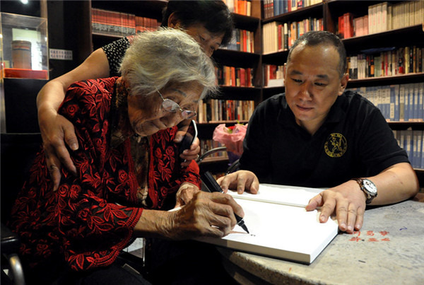 Wu Xianbing (right) speaks with the widow of a Chinese soldier who died fighting the Japanese in 1941. (China Daily)