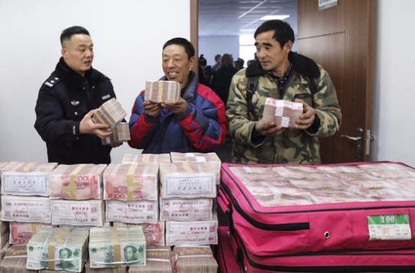 Migrant workers receive wages that police helped them recover from employers who defaulted on payments in Shenyang, Liaoning province, on Tuesday. （Cai Jingyu/For China Daily）