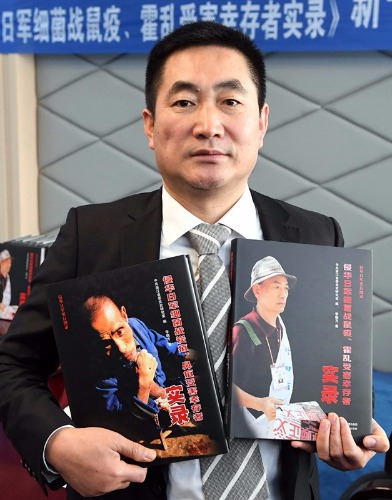 Li Xiaofang shows his books on the victims of Japanese germ warfare in China during World War II. He was in Anda, Heilongjiang province, on Wednesday. (Liu Yang/For China Daily)