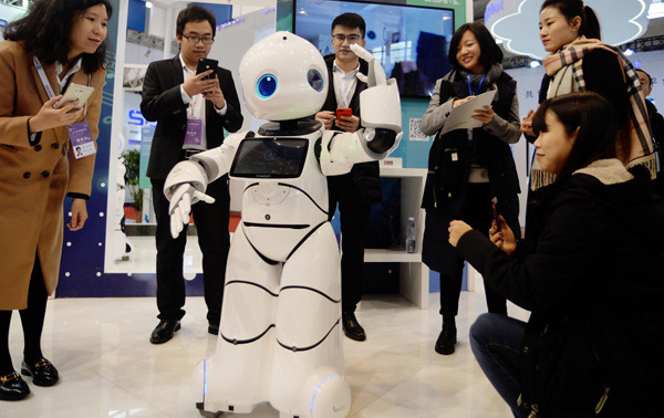 Visitors interact with robots during an AI expo in Nanjing, Jiangsu province. (Photo by Cui Xiao/For China Daily)