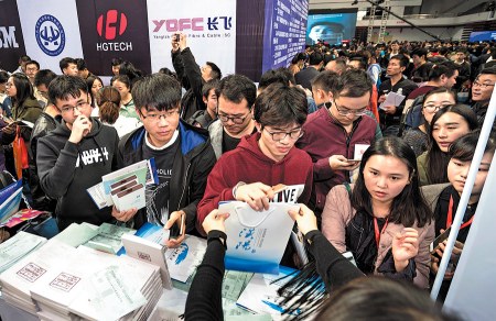 College graduates look for jobs at a hiring event on campus at Huazhong University of Science and Technology in Wuhan, Hubei province. Wuhan is offering graduates affordable housing, more easily obtained residence permits and other perks to attract talent to the city.  (Photo/Xinhua)