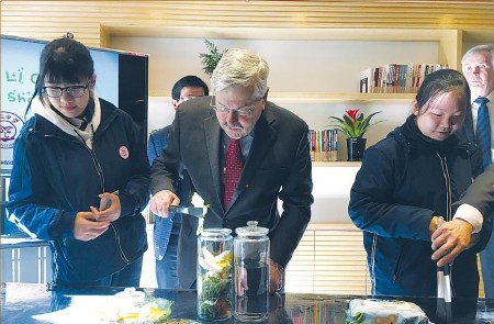 Terry Branstad learns to make fertilizer with kitchen waste, vegetable leaves and fruit peels. (Photo/China Daily)