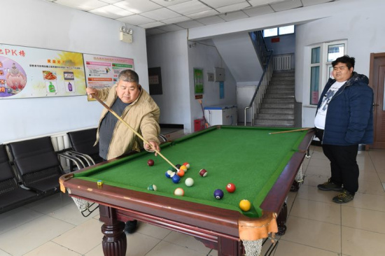 Tian Shiguang (L), 53, and his son Tian Hua, 29, play billiards at a weight-losing hospital in Changchun. [Photo provided to chinadaily.com.cn]