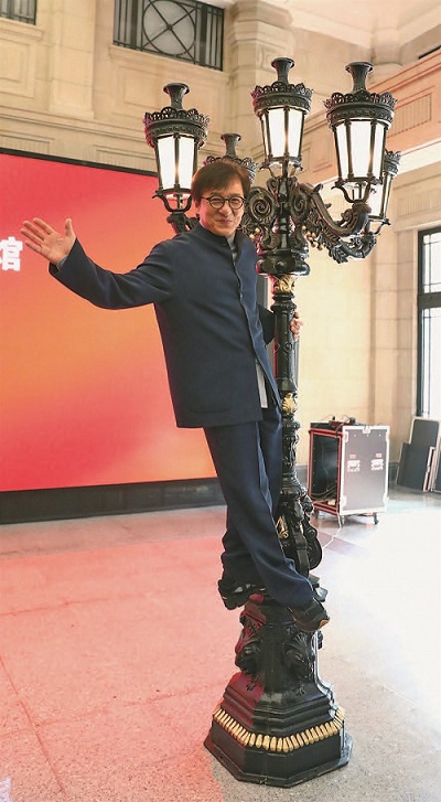 Film actor Jackie Chan climbs on to a replica of an antique street lamp as he poses for the press at the Shanghai History Museum yesterday. (Jiang Xiaowei)