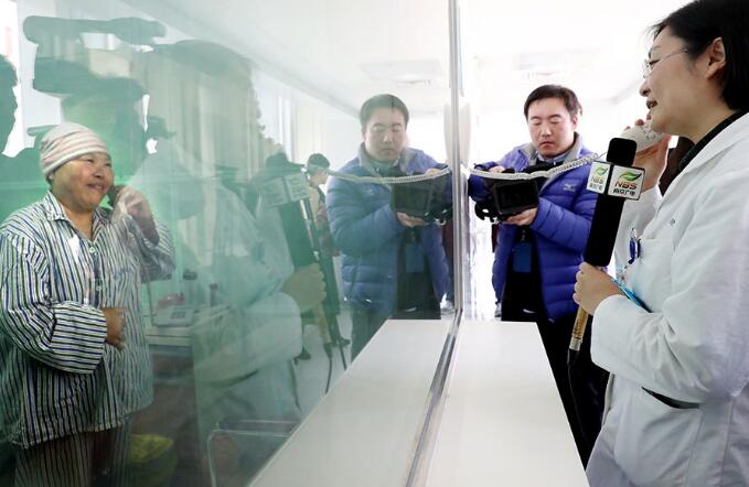 A doctor at Nanjing Drum Tower Hospital checks Wang Ling, standing in a germ-free room, after her stem cell transplant surgery. Photo provided to China Daily)