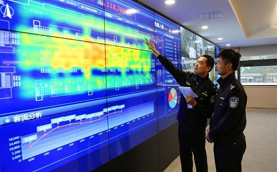 Two police officers of Shanghai Hongqiao Railway Station analyze the data mapped on the screen. (Ti Gong)