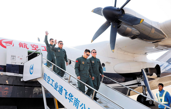 Crew members disembark from the amphibious aircraft AG600 on Sunday. (CHEN XIAO / FOR CHINA DAILY)