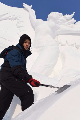 Zhou Yanzhi works on the snow sculpture. (Liu Yang/For China Daily)