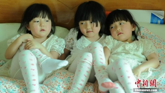 The triplets at their fourth birthday on May 27, 2014. /Chinanews Photo