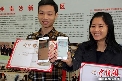 Guangdong residents show their newly applied e-ID cards to media. (Photo/Chinanews.com)