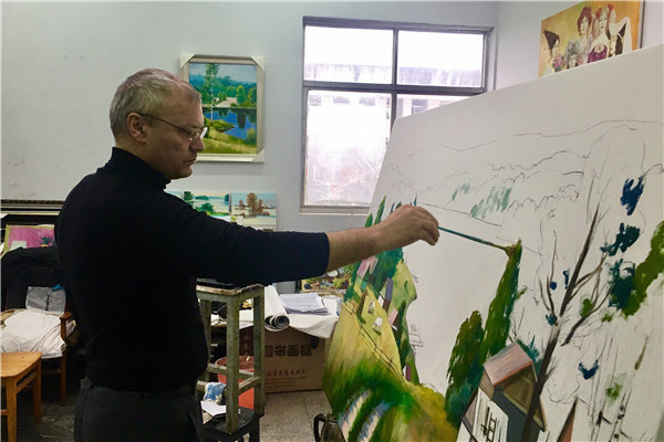 Vladimir Ganin paints in his studio at the Hunan Institute of Science and Technology. (Cheng Si/China Daily)