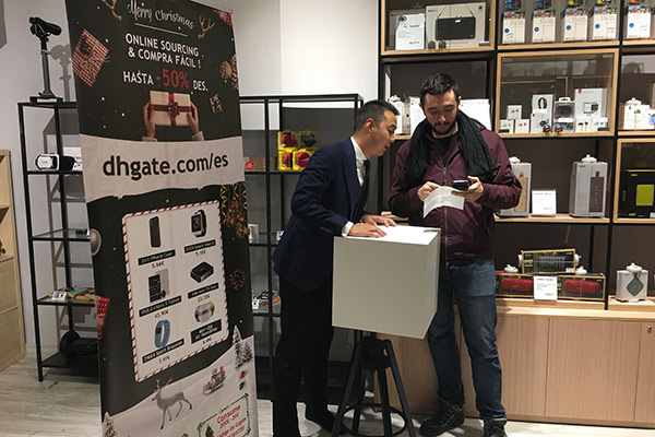 A consumer takes part in a draw of lots during the opening ceremony for DHgate.com's Digital Trade Center in Madrid on Dec 11. (Photo provided to China Daily)