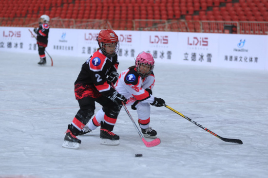 Children play ice hockey at the Bird's Nest, or the National Stadium, in Beijing on Dec 23. Cheng Gong/For China Daily