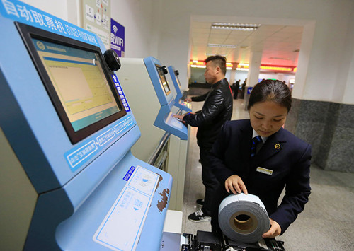 A railway worker maintains a self-service ticket vending machine at Kaili Railway Station in Guizhou province on Tuesday. (Photo/Xinhua)
