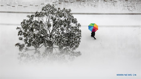 A pedestrian walks on a snow-covered street in Tancheng County, east China's Shandong Province, on Jan. 4, 2018. Many places across China saw snowfall from Wednesday. (Xinhua/Zhang Chunlei)