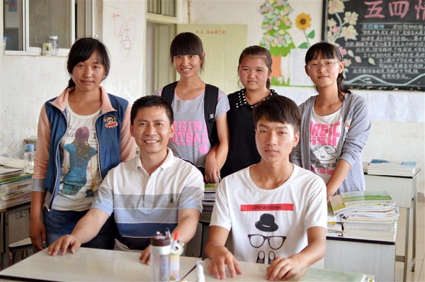 Liu Zhexin (left, sitting) visits the Yi minority students he sponsors in Yunnan Province.(Ti Gong)