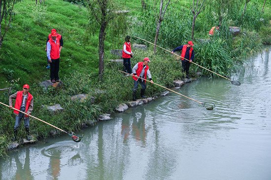 Workers clean a river in Changxing county, Zhejiang province, in October. The county has invested 7.5 billion yuan ($1.15 billion) in improving its waterways and the aquatic environment over the past three years. (Photo/Xinhua)