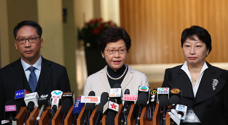 Hong Kong Chief Executive Carrie Lam Cheng Yuet-ngor (center) speaks to the media on Friday with new Secretary for Justice Teresa Cheng Yeuk-wah (right) and Rimsky Yuen Kwokkeung, who is leaving the post. (Photo/China Daily)